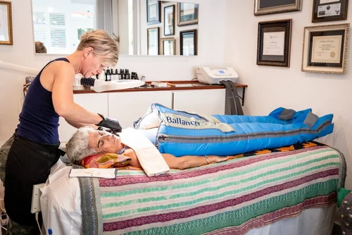 A client reclined in the Ballancer Pro compression suit while Ewa works alongside